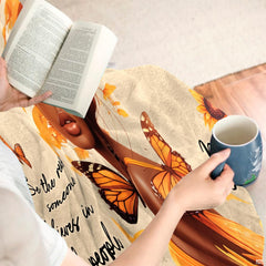 Empowering floral woman throw blanket draped across a living room chair.