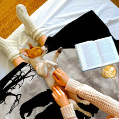 Lunar Bigfoot throw blanket displayed in a relaxed home lounge setting with a puppy.