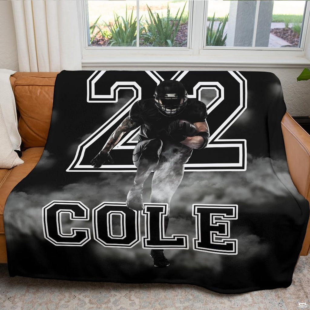 Atmospheric game day fan cave couch display featuring charging football player graphic throw blanket