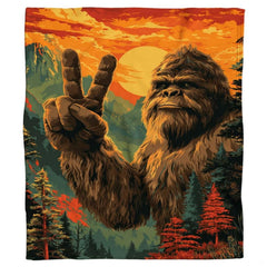 Vibrant illustration of Bigfoot flashing a peace sign against an alpine mountain sunset and pine forest.