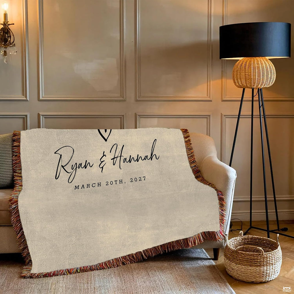 Close-up of fluid black cursive lettering and hand-drawn heart motif on an oatmeal background blanket