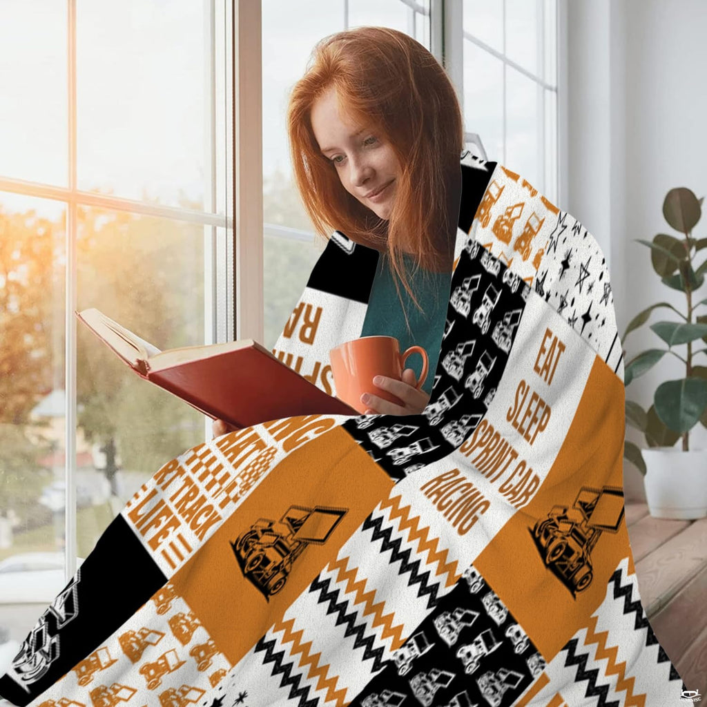 Close-up of the winged sprint car vector illustration, racing slogans, and star scatter patterns on a throw blanket