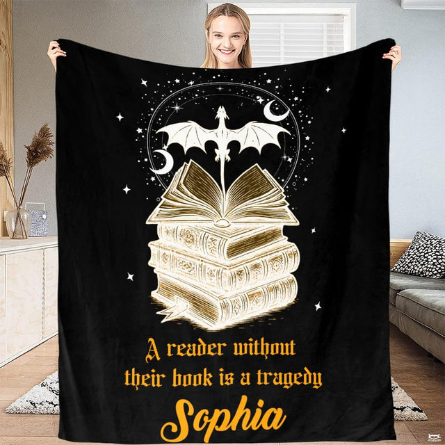 Full view of black throw blanket with golden dragon soaring above stacked antique tomes and crescent moons.