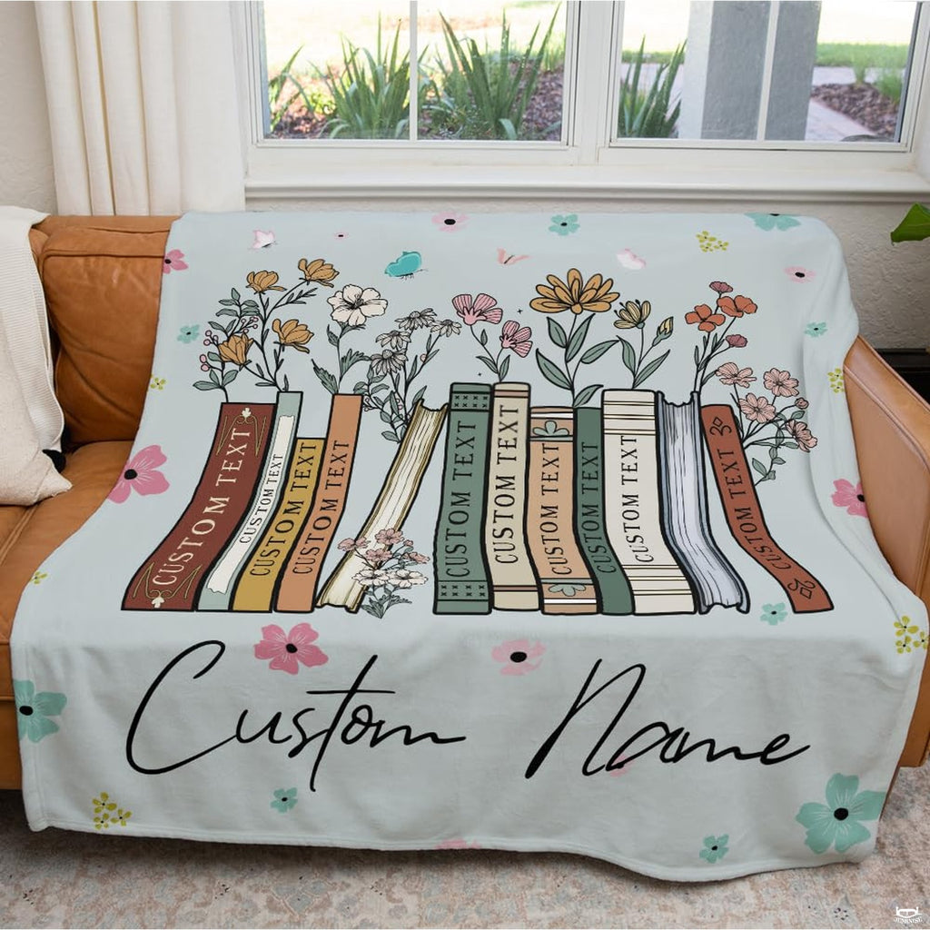 Bedroom setting with a puppy resting on the wildflower books throw blanket next to an open book.