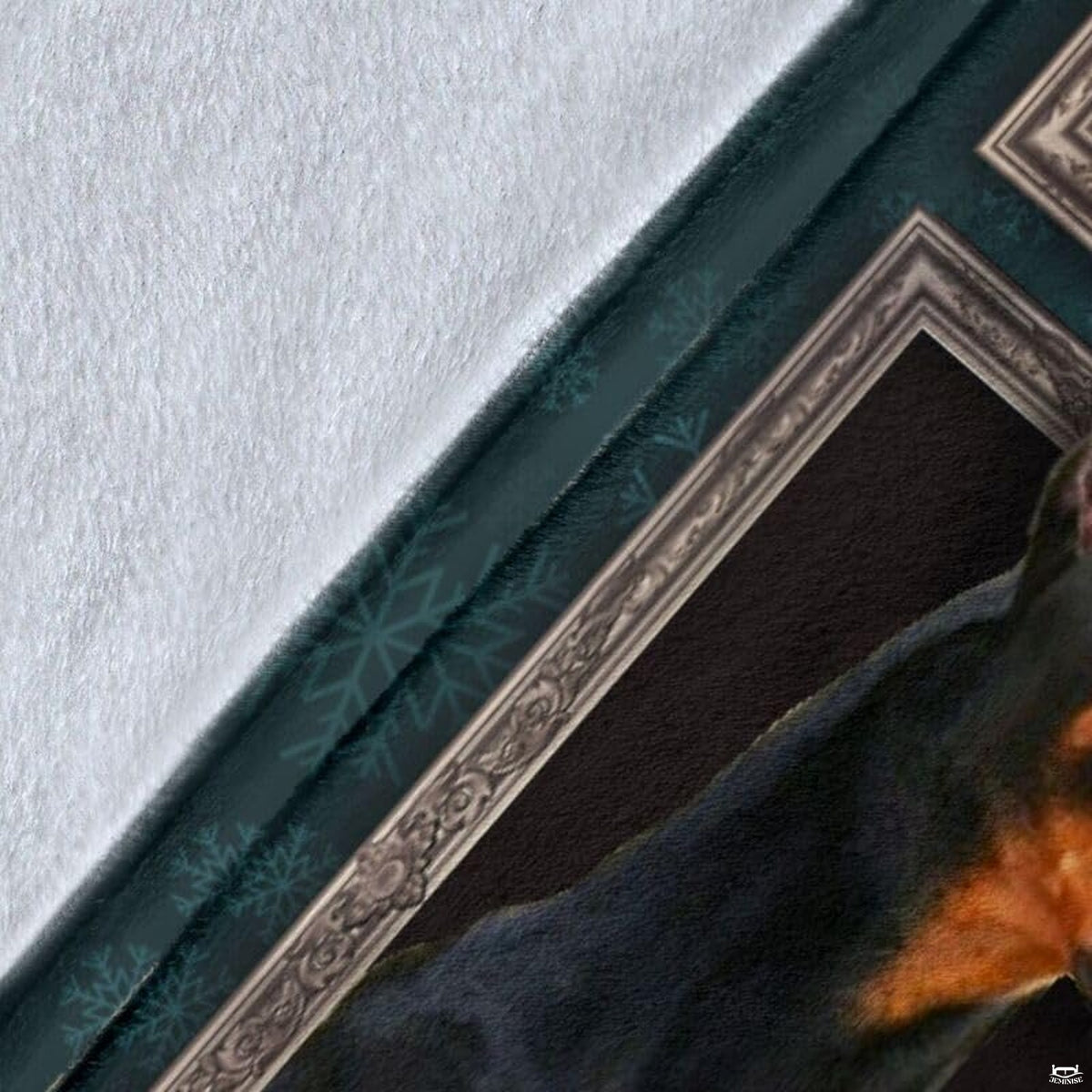 Close-up detail shot of the Doberman Pinscher blanket showing edge detail and teal snowflake art.