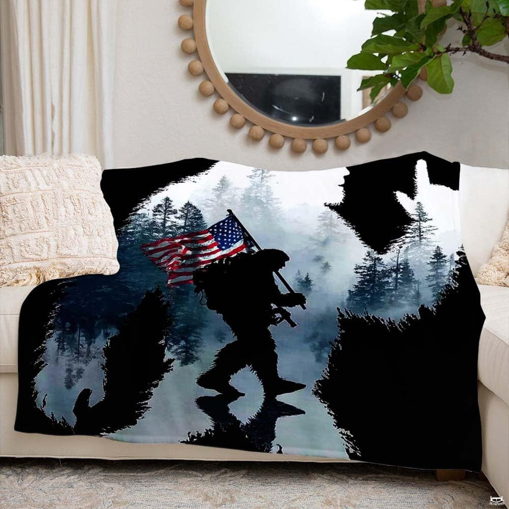 Close-up detail of the printed evergreen pine trees and soldier silhouette on the throw blanket