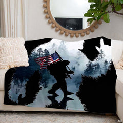 Close-up detail of the printed evergreen pine trees and soldier silhouette on the throw blanket