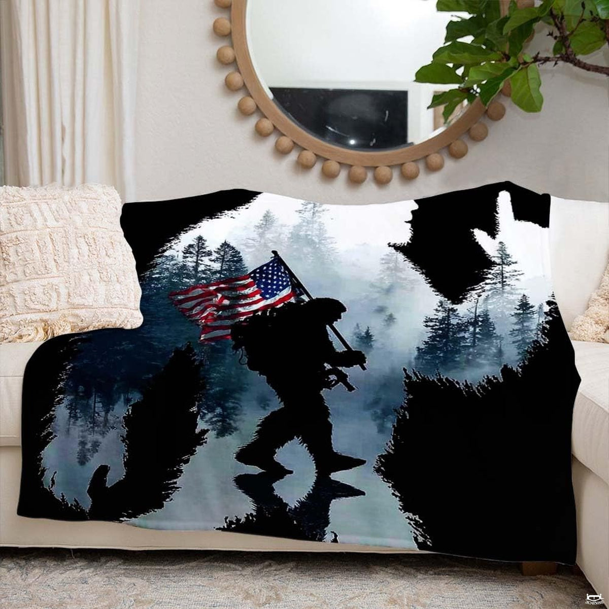 Close-up detail of the printed evergreen pine trees and soldier silhouette on the throw blanket