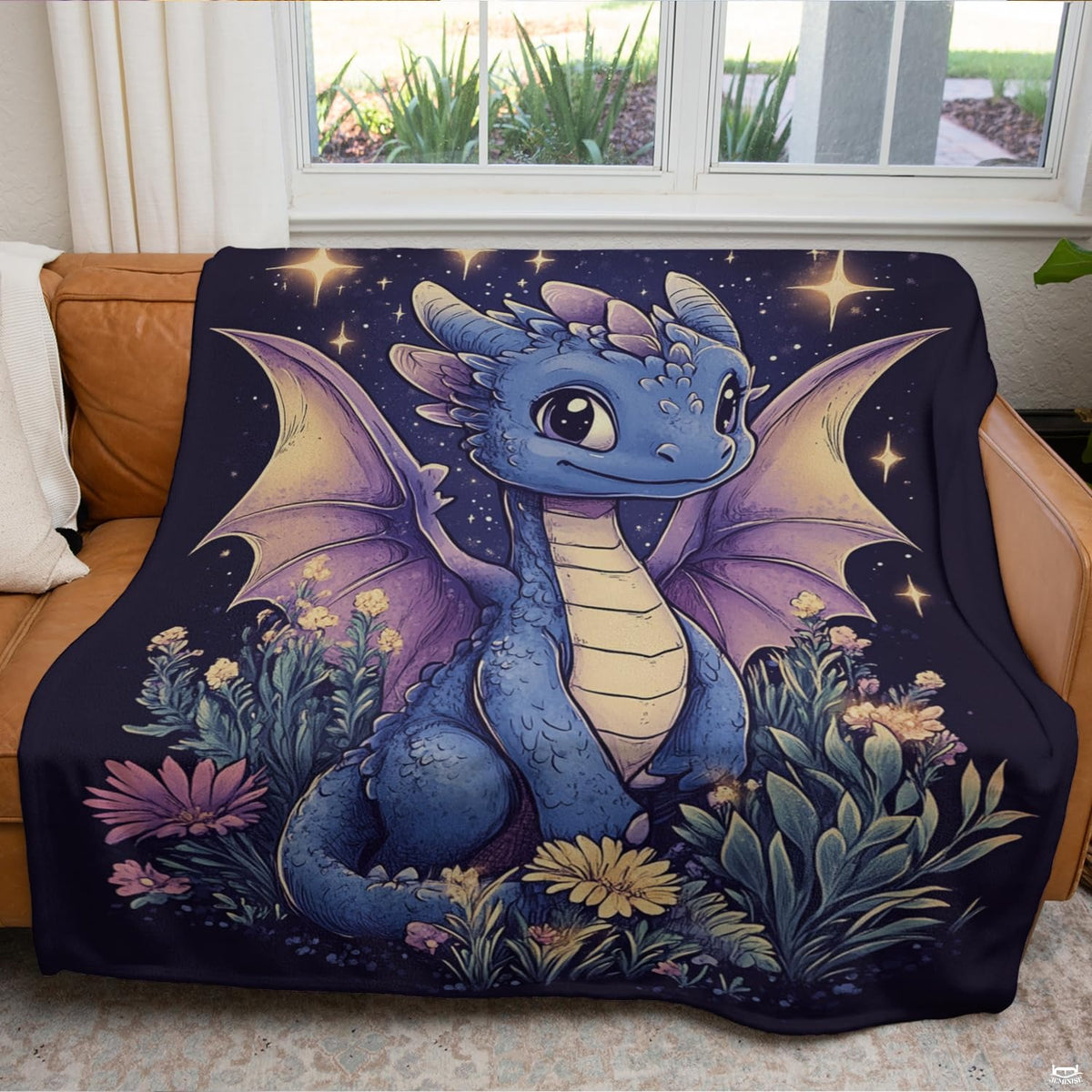 Illustrated baby blue dragon starry meadow throw blanket folded neatly on an armchair.