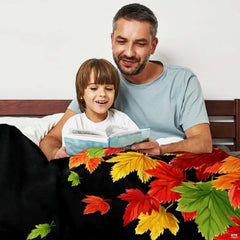 Close-up perspective of colorful maple leaves on dark throw blanket
