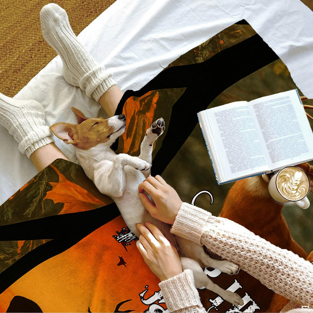 Lifestyle scene showing a small dog on the printed autumn wildlife textile next to an open book.