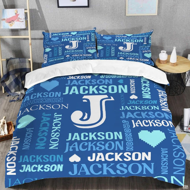 Blue monogram bedding displaying crisp white initial letter surrounded by royal blue and cyan word-cloud typography
