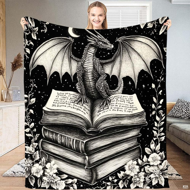 Gothic dragon throw blanket featuring black and white dragon on open book stack under crescent moon.