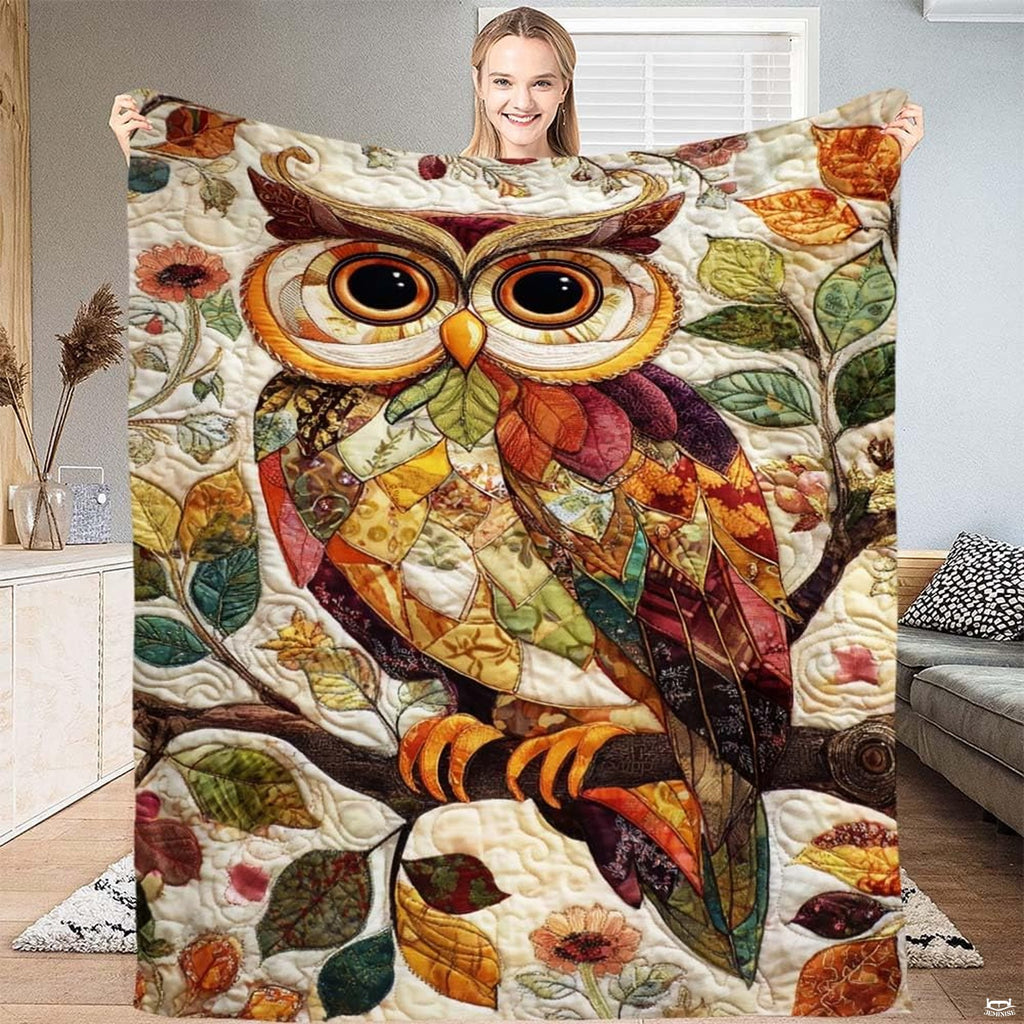 Whimsical collage-style horned owl perched on a branch amid autumn leaves on a throw blanket