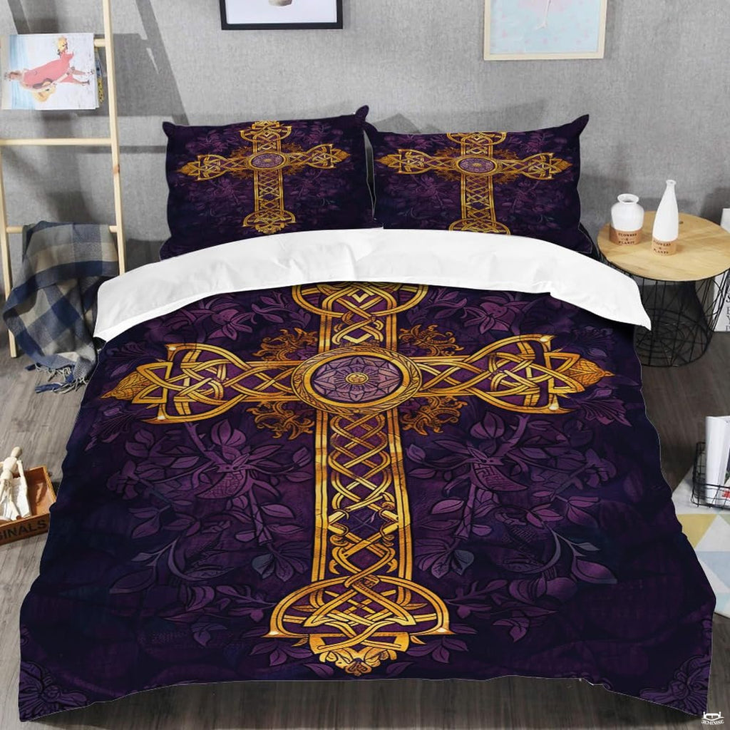 Close-up of golden Celtic cross knotwork medallion and filigree scrollwork on rich purple botanical artwork bedding.