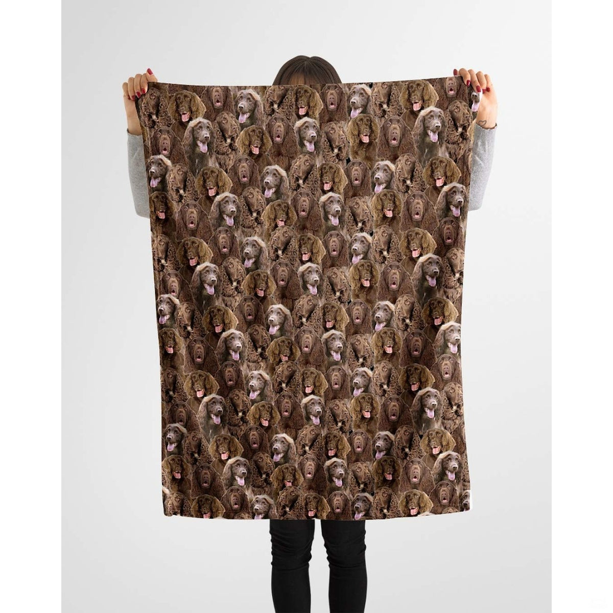 Model holding up a repeating chocolate brown spaniel canine blanket against a plain background.