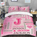Pink monogram bedding displaying bold magenta initial letter surrounded by multidirectional word-cloud typography