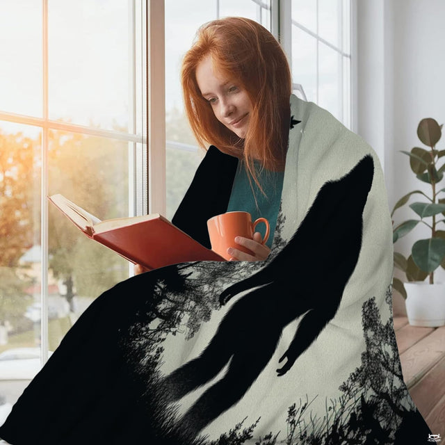 Woman sitting beside a window reading a book draped in the starry forest Bigfoot print textile.