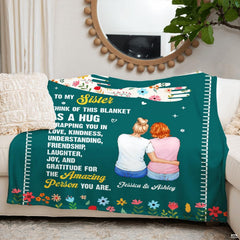 Close-up perspective of the sisterhood artwork on deep teal plum colored bedding.