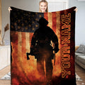 Firefighter silhouette holding axe against distressed American flag with rising embers on Blanket.