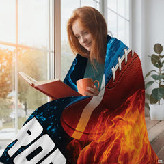Young woman reading by window wrapped in vibrant fire and water football throw blanket