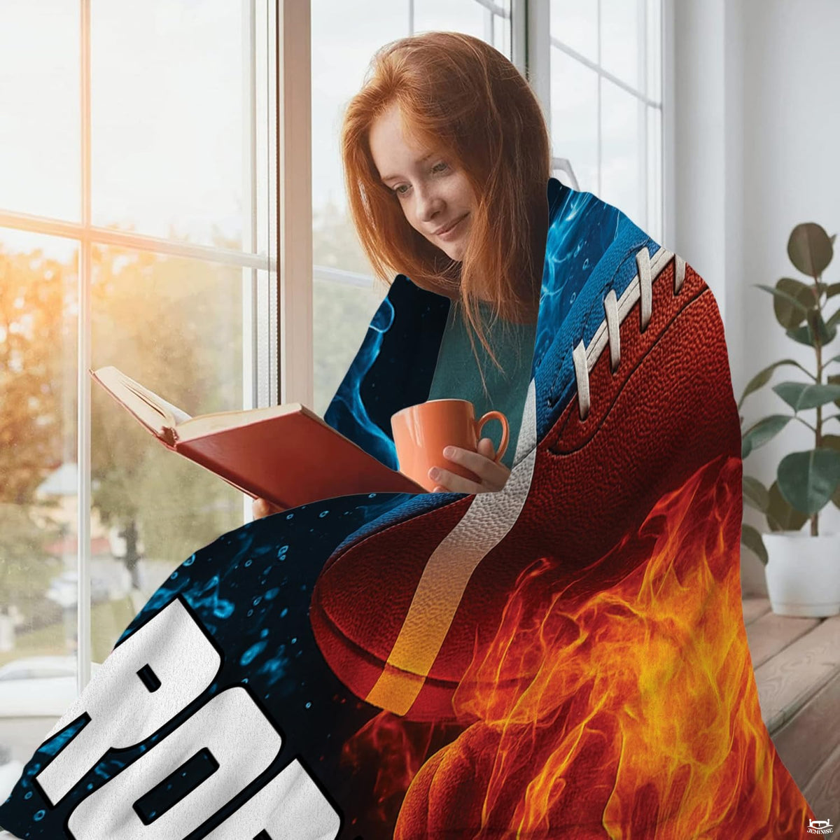 Young woman reading by window wrapped in vibrant fire and water football throw blanket
