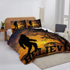 Overhead view of retro sunset Bigfoot bedding arranged neatly across a rustic cabin mattress