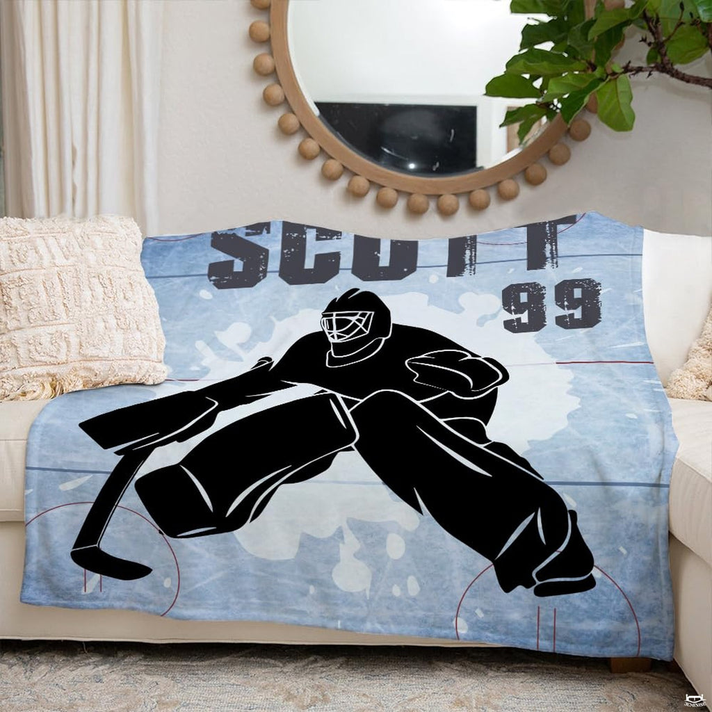 Hockey goalie silhouette sports blanket styled neatly across an ivory living room couch.