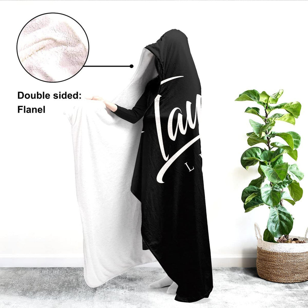 Side view of soccer sports blanket draped over shoulders displaying white inner lining beside indoor greenery.