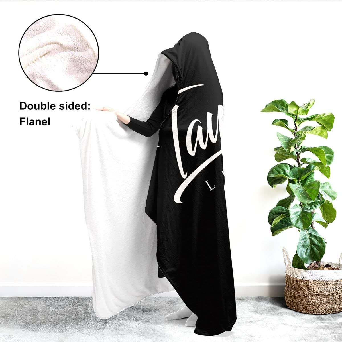 Side view of soccer sports blanket draped over shoulders displaying white inner lining beside indoor greenery.