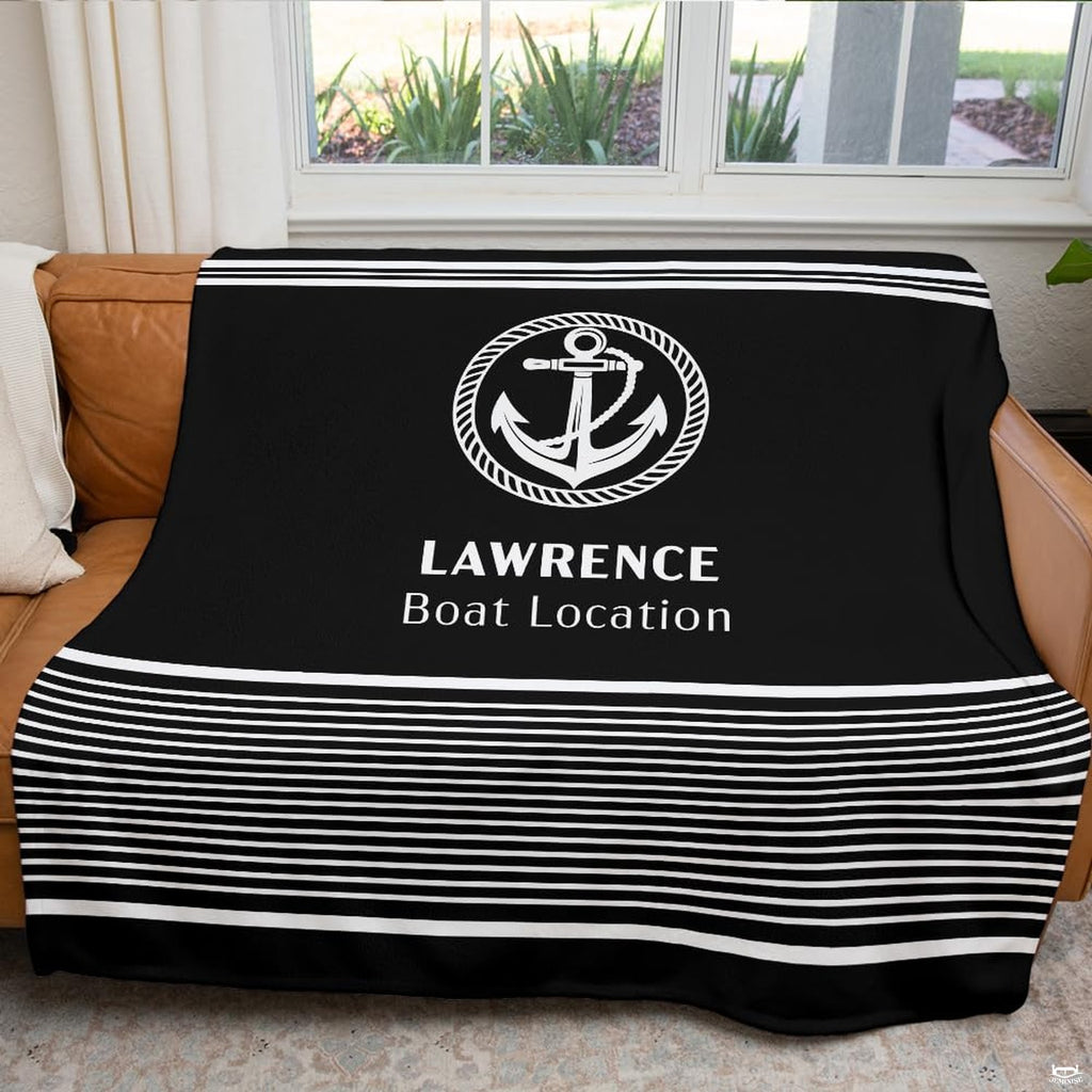 Black and white nautical anchor print arranged across a couch in front of a bright window.