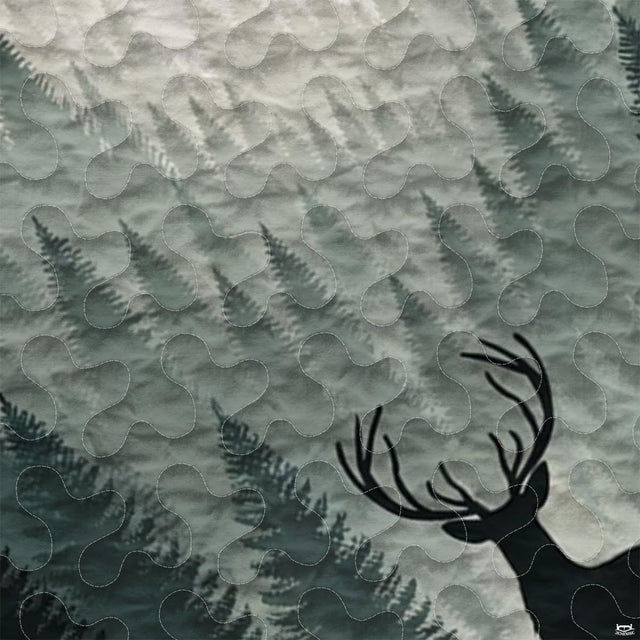 Close-up of decorative pine tree bedspread border featuring plaid squares and stylized evergreens.
