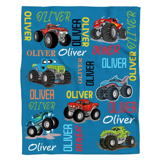 Woman holding open monster trucks throw blanket showing colorful cartoon vehicles and typography