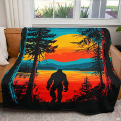 Folded Bigfoot sunset throw blanket showcasing the warm orange horizon and plush white underside