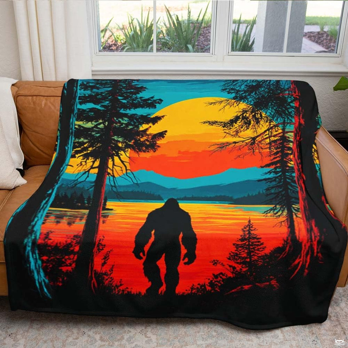 Folded Bigfoot sunset throw blanket showcasing the warm orange horizon and plush white underside