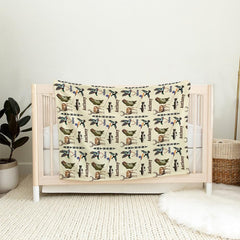 Rustic wildlife hunting and fishing throw blanket draped over a wooden nursery crib rail