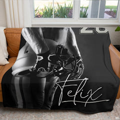Atmospheric sports fan cave couch display featuring black and white football throw blanket
