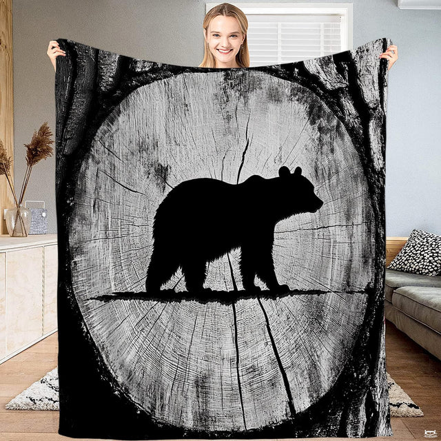 Rustic tree ring bear silhouette throw blanket featuring bear silhouette inside circular wood cross section