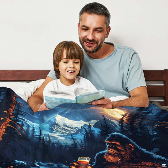 Bigfoot campfire beer mountain throw blanket view 2 styled on living room couch in modern home