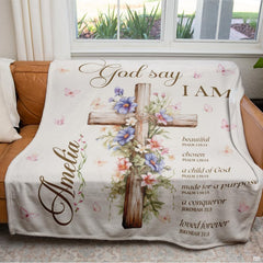 Close-up perspective of timber cross and purple floral blossoms on throw blanket