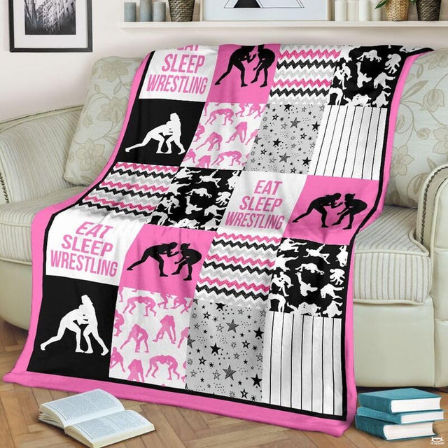 Girls wrestling patchwork blanket draped over a living room couch beside a stack of books.