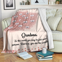 Cherry blossom family tree blanket styled over living room sofa beside accent pillows
