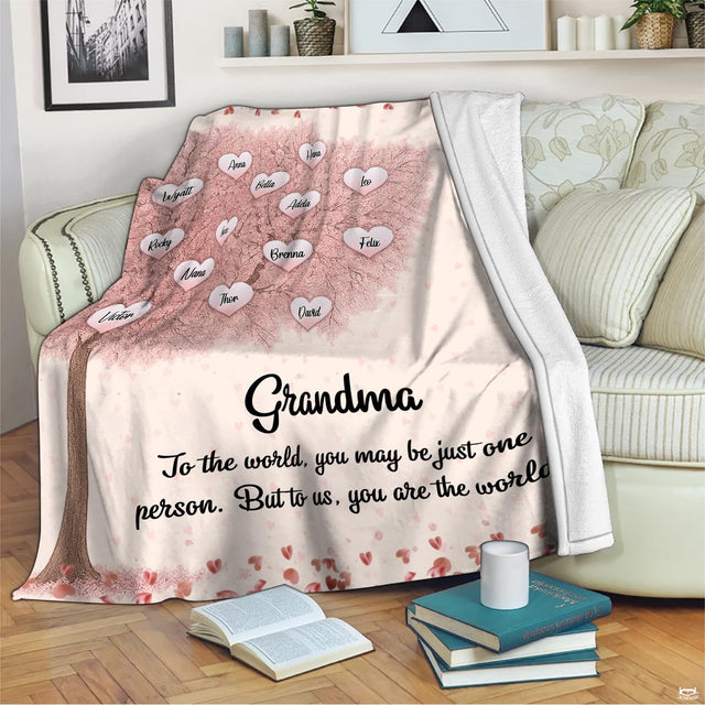 Cherry blossom family tree blanket styled over living room sofa beside accent pillows