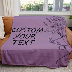 Botanical morning glory flower letter throw blanket styled over a contemporary living room sofa
