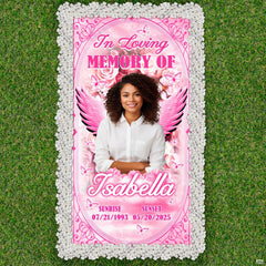 Aerial display of pink angel wings cemetery tribute bordered by white pebbles on green lawn.