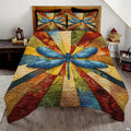 Retro dragonfly botanical autumn patchwork bedding set displayed neatly on a bed in a rustic bedroom