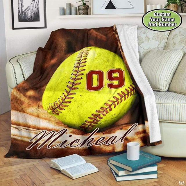 Close-up perspective of yellow softball ball markings and mitt webbing on sports blanket