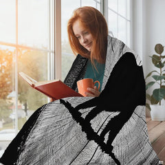 Folded rustic tree ring bear throw blanket resting on wooden table displaying concentric wood grain