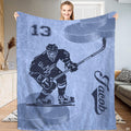 Full view of ice hockey skater gliding across a frosty ice blue background on a sports blanket.