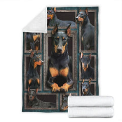 Folded corner and rolled layout of the Doberman Pinscher blanket showing the white reverse side.